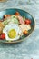 Caesar salad with fried egg. Beautiful serving dishes. Light gray background. Restaurant menu