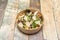 Caesar salad with parmesan cheese flakes, croutons and lettuce shoots with arugula in cardboard bowl for home delivery