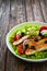 Caesar style salad - fried breaded chicken breast and vegetables on wooden table