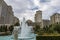 Caesars Palace Hotel, Casino and resort along the Las Vegas strip with tall lush green trees, water fountains, statues, blue sky