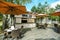 Cafe in light colors outside, clear sky, umbrellas, tables and chairs