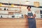 Cafe owner standing at counter with a cup of coffee