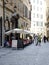 Cafe tables and tourists of cobblestone street in Genoa, Italy