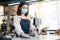 Cafe waiter wear mask, clean restaurant with sanitizer to open store. Asian attractive young woman disinfecting, wiping and