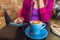 Cafe woman drinking cappuccino coffee cup using mobile phone app. Urban lifestyle young people addicted to social media online