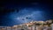 Cagliari panorama at night with lightning strikes behind the city. Lightning storm on night sky, over the city.