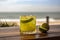 Caipirinha cocktail on a wooden table with a mesmerizing sea, beach background, evoking relaxing, tropical paradise vibe