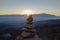 Cairn with mountains in the background at sunset