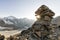 Cairn with sunray in the alps with glacier in the background