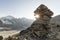 Cairn with sunray in the alps with glacier in the background