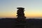 Cairn at sunrise, stones balances, pyramid of stones at sunset, concept of life balance, harmony and meditation. A pile of stones