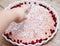 Cake or baked pudding of cottage cheese red bilberry white baking dish wooden background cutting hand