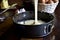 Cake batter being poured into a cake tin