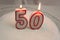 A cake with burning candles that form the number 50
