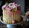 cake dripping in gold and pink with flowers
