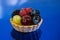 Cake with fresh bio fruits, grapes, raspberries, blackberries, side view photo, mirror blue background