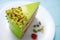 Cake with fruity cream and pistachio decorated with nuts, isolated