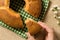 Cake made of corn. Sweet food of Festa Junina, a typical brazilian party, holiday event in June. Hand picking up a slice on green