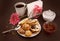 Cake roll and eclair on plate with coffee on dark background