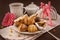 Cake roll and eclair on plate with coffee on dark background