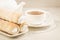 cake a tubule with white cream and tea cup/ tea drinking with cream cakes on a white table. Selective focus