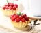 Cakes with cream and juicy ripe raspberries, spoon on a linen napkin on a light background
