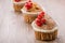 cakes decorated with red berries on a wooden table/cakes decorated with red berries on a wooden table. copy space