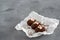 Cakes made of chocolate on a white transparent paper on a gray background. Cakes decorated with red jelly and delicate white cream