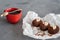 Cakes made of chocolate on a white transparent paper on a gray background. Cakes decorated with red jelly and delicate white cream