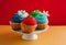 Cakestand with colorful cupcakes decorated with sparkles