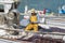 Cala Figuera, Mallorca, Spain - 05.02.2022: Fisherman in yellow fishing suit on a boat untangling fishing net