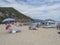 Cala Gonone, Sardinia, Italy, September 9, 2020: Cala Luna beach with sunbathing people and tourist ship boat. White sand beach