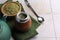 Calabash, bombilla, bowl of mate tea leaves and teapot on tiled table, space for text