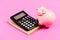 Calculate profit. Piggy bank pink pig and calculator. Economics and finance. Credit concept. Money saving. Save money