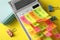 Calculator covered with stickers on yellow background, closeup. April fool`s day