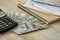 Calculator, dollars notepad on a wooden background, close-up