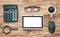 Calculator, glasses, tablet, coffee on wooden background