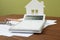 Calculator, house model, keys and documents on table. Real estate agent`s workplace