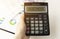 A calculator with the inscription BUSINESS is placed in the stack of documents. Business concept