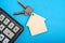 Calculator and keychain with house keys blue background.Concept mortgages, buying and renting housing