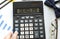 A calculator labeled DEADLINE lies on financial documents in the office. Business concept