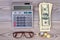 Calculator, money and glasses.