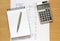 Calculator notebook pen and financial figures