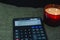 calculator, notes in a notebook against the background of candles, the concept of calculating profits, losses, expenses