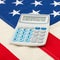 Calculator over big US flag - accounting concept