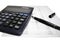 Calculator and pen on balance sheet