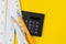 Calculator, pencils and white measuring tapes with centimetre and inches on vivid yellow background, length, long or maker