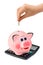 Calculator, piggy bank and hand with coin