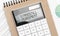 Calculator with text standstill agreement with craft colored notepad pen and financial documents