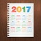 Calendar for 2017 Year on a dark wooden background. Hand drawn colorful text. Notebook paper. Corporate business layout.
